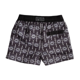 Black Kids swim shorts with white geometric treillage repeat pattern on a black background with black elasticated and drawstring waistband